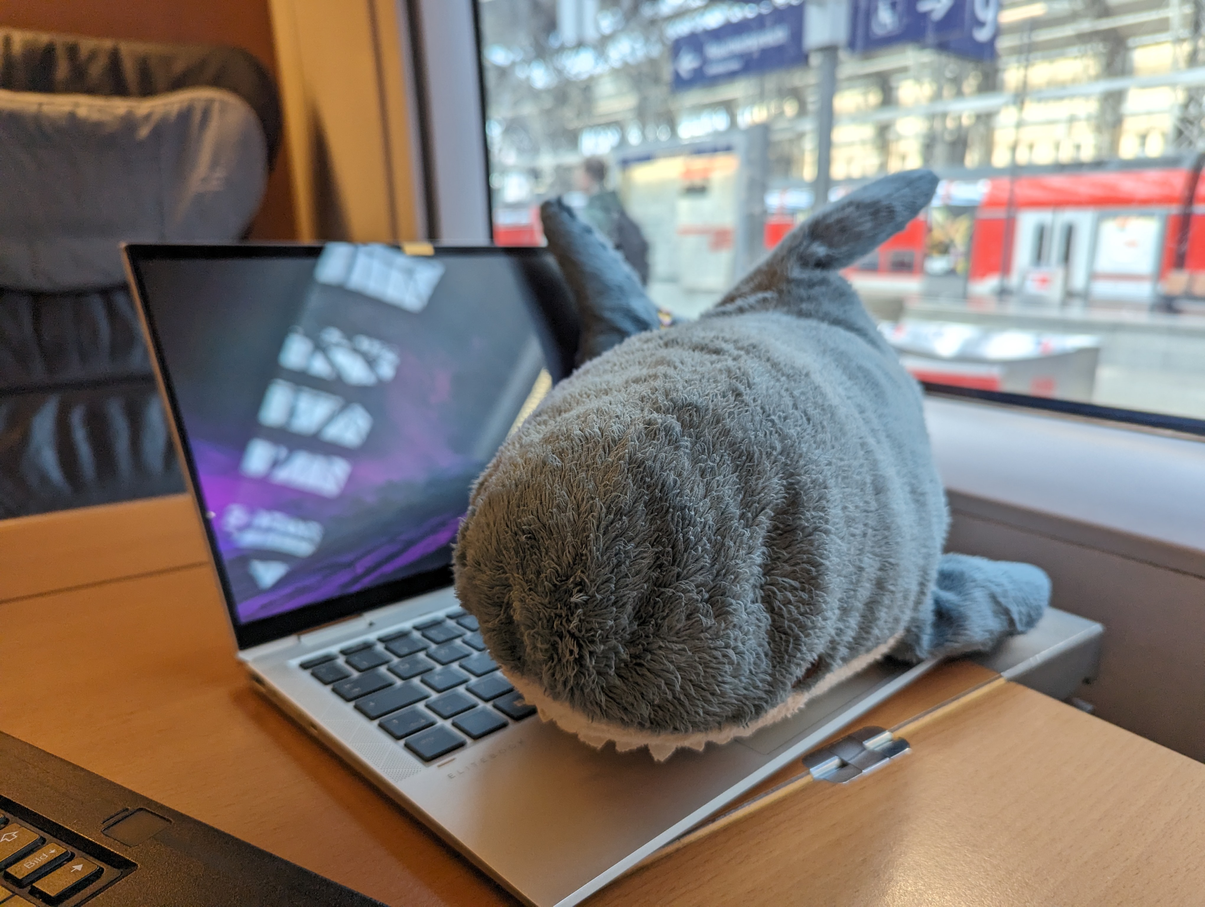 Keith Hajring on a train, lying on a laptop.