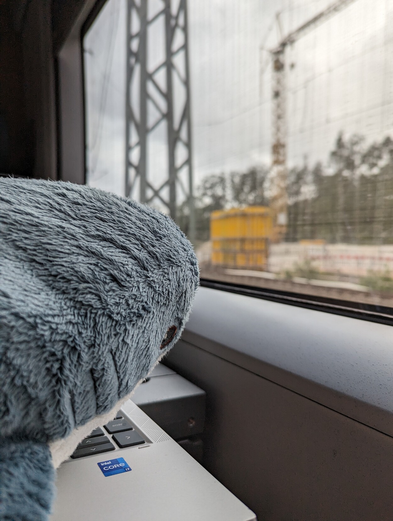 Keith Hajring is looking out of a train window. There is a construction site on the outside.